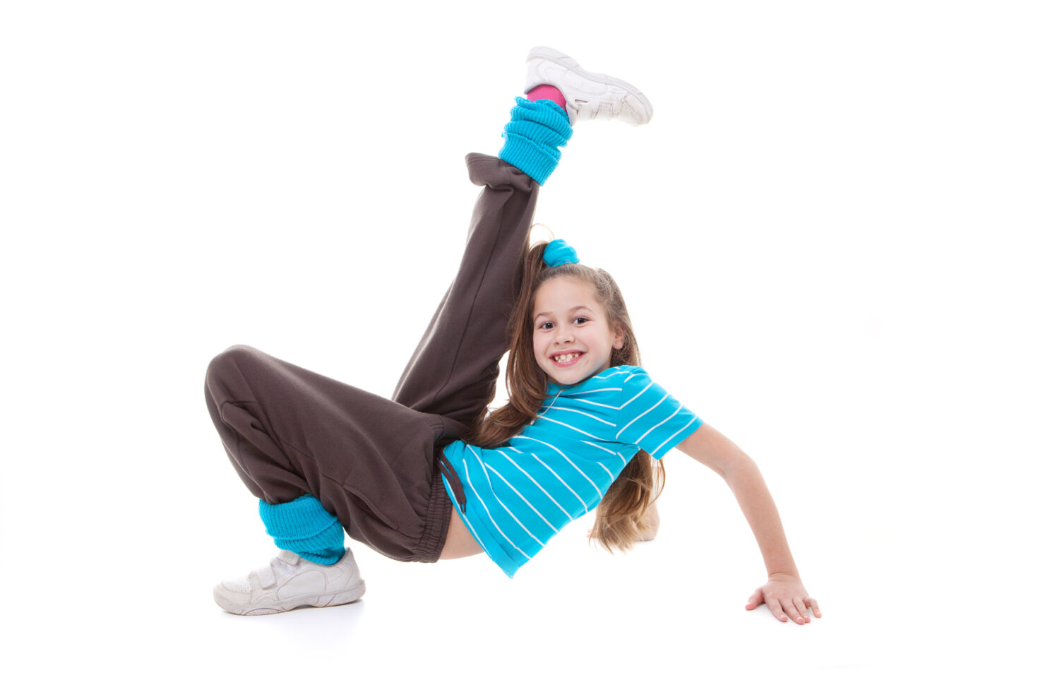 Irene K. - Ein lächelndes junges Mädchen in einem blau gestreiften Hemd, einer braunen Hose und blauen Stulpen posiert in einer dynamischen Hip-Hop-Breakdance-Bewegung vor einem weißen Hintergrund - die perfekte Energie für Tanzkurse in Ihrer örtlichen Tanzschule.